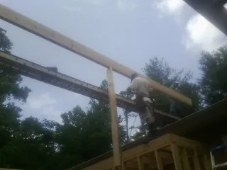 Carpenter setting a ridge beam over a new addition frame — Ice Dam Removal by Roofing Brothers in Berry Creek