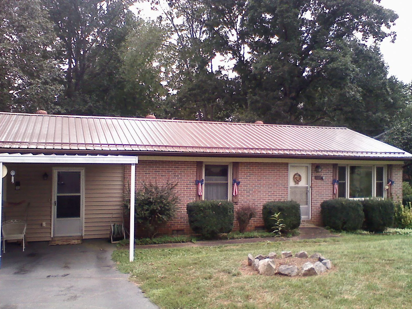 Bronze metal roof and carport on a brick ranch home — Roof Repair work by our crew in Berry Creek